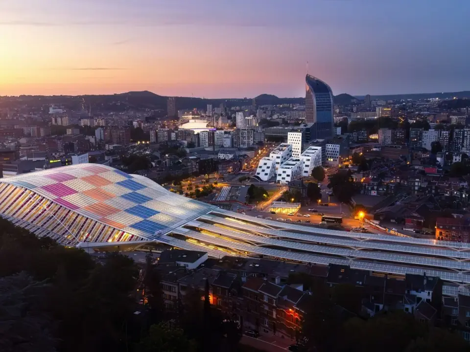 Toiture colorée du projet Paradis Express au crépuscule, avec Liège en arrière-plan